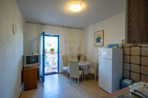 a small kitchen with a table and a refrigerator at Apartments with parking space Pasman - 8214 in Pašman