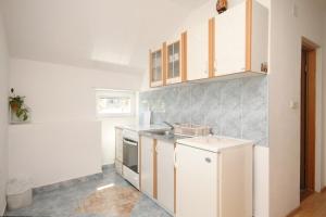 a kitchen with a sink and a stove at Apartments by the sea Tkon, Pasman - 8227 in Tkon