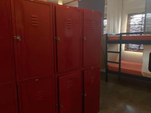 a group of red lockers in a room with a bunk bed at Moon Fools Hostel in Panglao