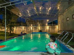 un petit enfant dans un tube intérieur dans une piscine dans l'établissement Quanho Villa, à Bắc Ninh