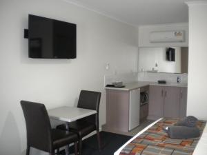 a kitchen with a table and two chairs and a small kitchen at Moama Central Motel in Echuca