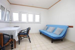 ein Wohnzimmer mit einem blauen Sofa und einem Tisch in der Unterkunft Apartments by the sea Tkon, Pasman - 8244 in Tkon