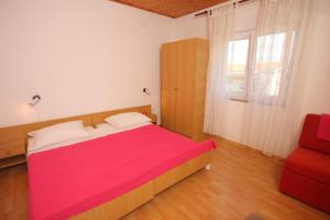 ein Schlafzimmer mit einem großen Bett und einem roten Stuhl in der Unterkunft Apartments by the sea Tkon, Pasman - 8244 in Tkon