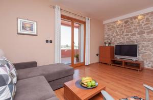 ein Wohnzimmer mit Sofa und Fernseher in der Unterkunft Apartments by the sea Poljana, Ugljan - 8432 in Poljana