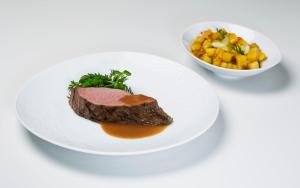a plate with a piece of meat and a bowl of vegetables at InterContinental Cascais-Estoril by IHG in Estoril