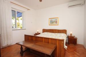 a bedroom with a bed and a table and a window at Apartments by the sea Kali, Ugljan - 8270 in Kali