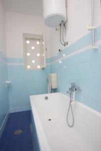 a blue and white bathroom with a tub and a sink at Apartments by the sea Kali, Ugljan - 8270 in Kali