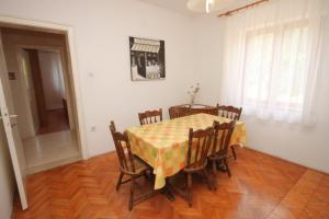 d'une salle à manger avec une table, des chaises et un chiffon de table jaune et blanc. dans l'établissement Apartments by the sea Kali, Ugljan - 8270, à Kali