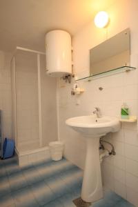 a white bathroom with a sink and a shower at Apartments by the sea Cavtat, Dubrovnik - 8610 in Cavtat +21 photos