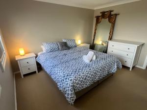 a bedroom with a bed and two night stands and a mirror at City Townhouse Bunbury in Bunbury
