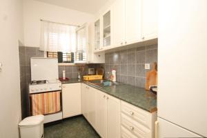 cocina con armarios blancos y nevera blanca en Apartments with a parking space Slano, Dubrovnik - 8547 en Slano
