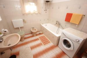 a bathroom with a sink and a washing machine in it at Apartments by the sea Ugljan - 8519 in Ugljan