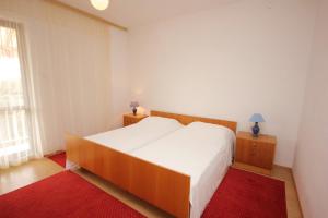 una camera con un grande letto bianco e un tappeto rosso di Apartments by the sea Muline, Ugljan - 8520 a Donje Selo