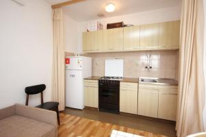 a kitchen with a white refrigerator and a stove at Apartments by the sea Muline, Ugljan - 8520 in Donje Selo