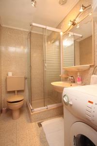 uma casa de banho com um chuveiro, um WC e um lavatório. em Apartments by the sea Dubrovnik - 8552 em Dubrovnik