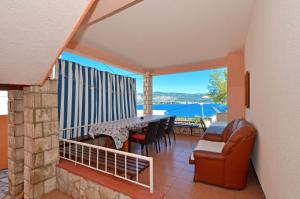 a dining room with a table and chairs and a balcony at Apartments by the sea Arbanija, Ciovo - 8651 in Trogir