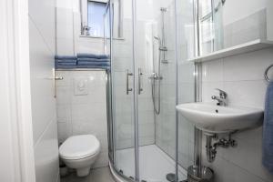 a bathroom with a shower and a toilet and a sink at Family friendly seaside apartments Duce, Omis - 8668 in Duće