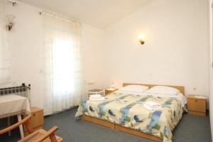 biała sypialnia z łóżkiem i oknem w obiekcie Apartments and rooms by the sea Kukljica, Ugljan - 8408 w mieście Kukljica