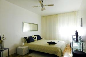 een slaapkamer met een bed en een plafondventilator bij Apartments with a parking space Dugi Rat, Omis - 8666 in Dugi Rat