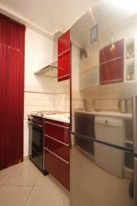 een keuken met rode kasten en een fornuis met oven bij Apartments with a parking space Dugi Rat, Omis - 8666 in Dugi Rat