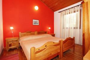 1 dormitorio con cama grande y pared roja en Apartments by the sea Rastici, Ciovo - 8619 en Trogir