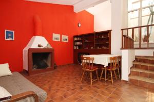 Habitación roja con mesa y chimenea en Apartments by the sea Rastici, Ciovo - 8619 en Trogir