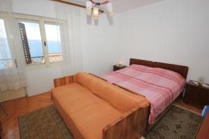 un letto con divano in una camera da letto di Apartments by the sea Suhi Potok, Omis - 8676 a Dugi Rat (Punta Lunga)