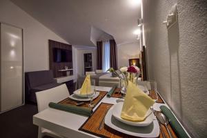 uma sala de estar com uma mesa de jantar com guardanapos amarelos em Studio Zecevo Rtic 8366a em Rogoznica