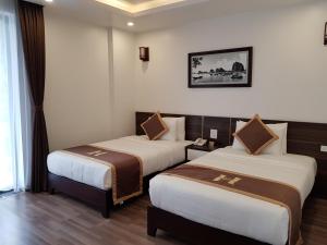 Postel nebo postele na pokoji v ubytování Helen Halong Hotel