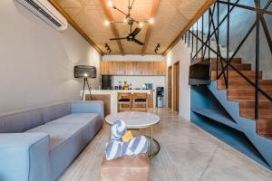 ein Wohnzimmer mit einem Sofa und einem Tisch in der Unterkunft Zazen 2 Villa by Hombali in Canggu
