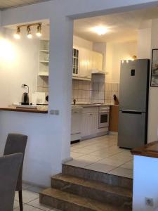 uma cozinha com um frigorífico, uma mesa e cadeiras em Apartments by the sea Duce, Omis - 8680 em Duće