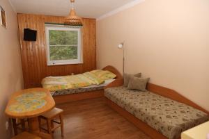 a bedroom with two beds and a table and a chair at Sea&Sand apartments in Juodkrantė