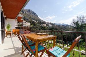 einen Holztisch und Stühle auf dem Balkon in der Unterkunft Apartments with a parking space Mlini, Dubrovnik - 8542 in Mlini
