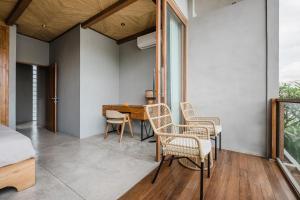 ein Schlafzimmer mit einem Tisch, Stühlen und einem Bett in der Unterkunft Zazen 2 Villa by Hombali in Canggu