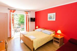 ムリニにあるApartments with a parking space Mlini, Dubrovnik - 8543の赤い壁のベッドルーム(ベッド1台付)