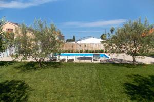 einen Hof mit Pool und einigen Bäumen in der Unterkunft Family friendly apartments with a swimming pool Biograd na Moru, Biograd - 8371 in Biograd na Moru