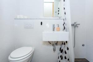 Baño blanco con aseo y lavamanos en Apartments and rooms by the sea Slano, Dubrovnik - 8737, en Slano