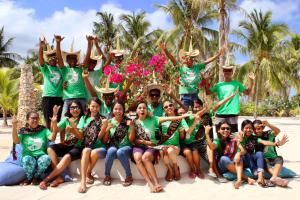 um grupo de pessoas posando para uma foto na praia em T-Land Resort em Nembrala