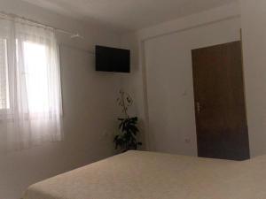 1 dormitorio con 1 cama y TV en la pared en Apartments by the sea Slano, Dubrovnik - 8599, en Slano