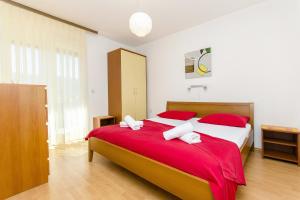 ein Schlafzimmer mit einem großen Bett mit roten Kissen in der Unterkunft Apartments with a parking space Stari Grad, Hvar - 8708 in Stari Grad