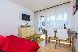 ein Wohnzimmer mit einem Tisch, Stühlen und einem TV in der Unterkunft Apartments with a parking space Stari Grad, Hvar - 8708 in Stari Grad