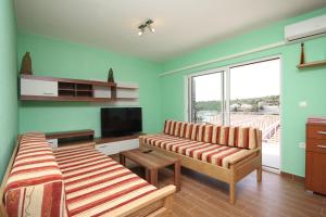 a living room with two beds and a flat screen tv at Apartments by the sea Basina, Hvar - 8754 in Vrbanj