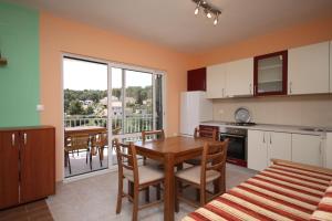 a kitchen and dining room with a table and chairs at Apartments by the sea Basina, Hvar - 8754 in Vrbanj