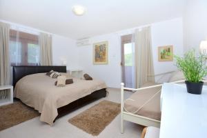 a white bedroom with a bed and a table at Holiday house with a swimming pool Basina, Hvar - 8731 in Vrbanj +21 photos