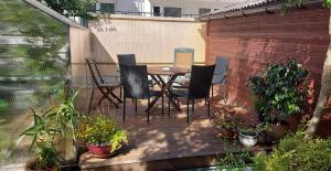 a patio with a table and chairs and potted plants at Studentiški apartamentai Palangoje in Palanga