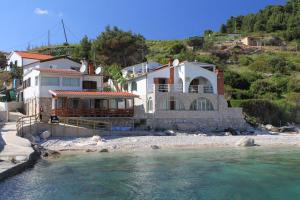 a house on a beach next to the water at Apartments and rooms by the sea Cove Zarace - Dubovica, Hvar - 8781 in Zarače
