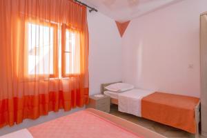 um quarto com 2 camas e uma janela com cortinas laranja em Studio Stari Grad 8726b em Stari Grad