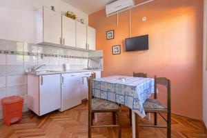 uma pequena cozinha com uma mesa e um lavatório em Studio Stari Grad 8726b em Stari Grad