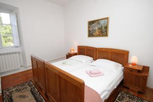 una camera da letto con un letto con lenzuola bianche e un asciugamano rosa di Apartments with a parking space Popovici, Dubrovnik - 8694 a Gruda