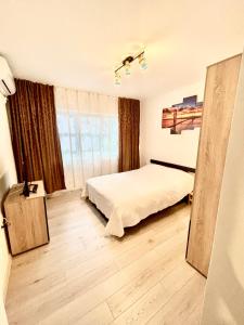 a bedroom with a bed and a large window at Apartment modern in Sulina in Sulina